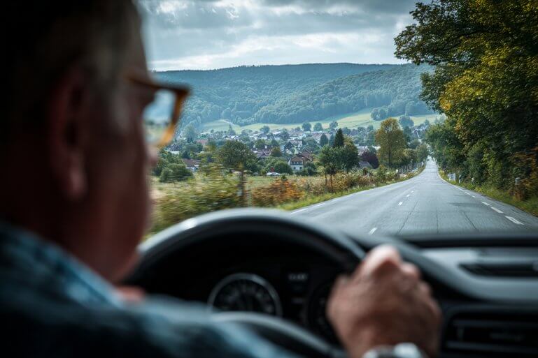 A driver's license and reading glasses resting on a newspaper with medical-related articles.